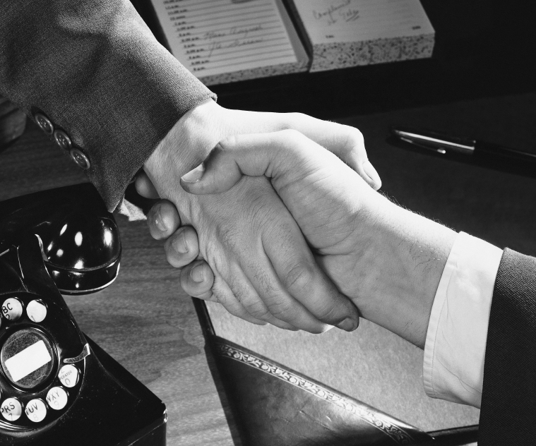 A black and white photo of a handshake